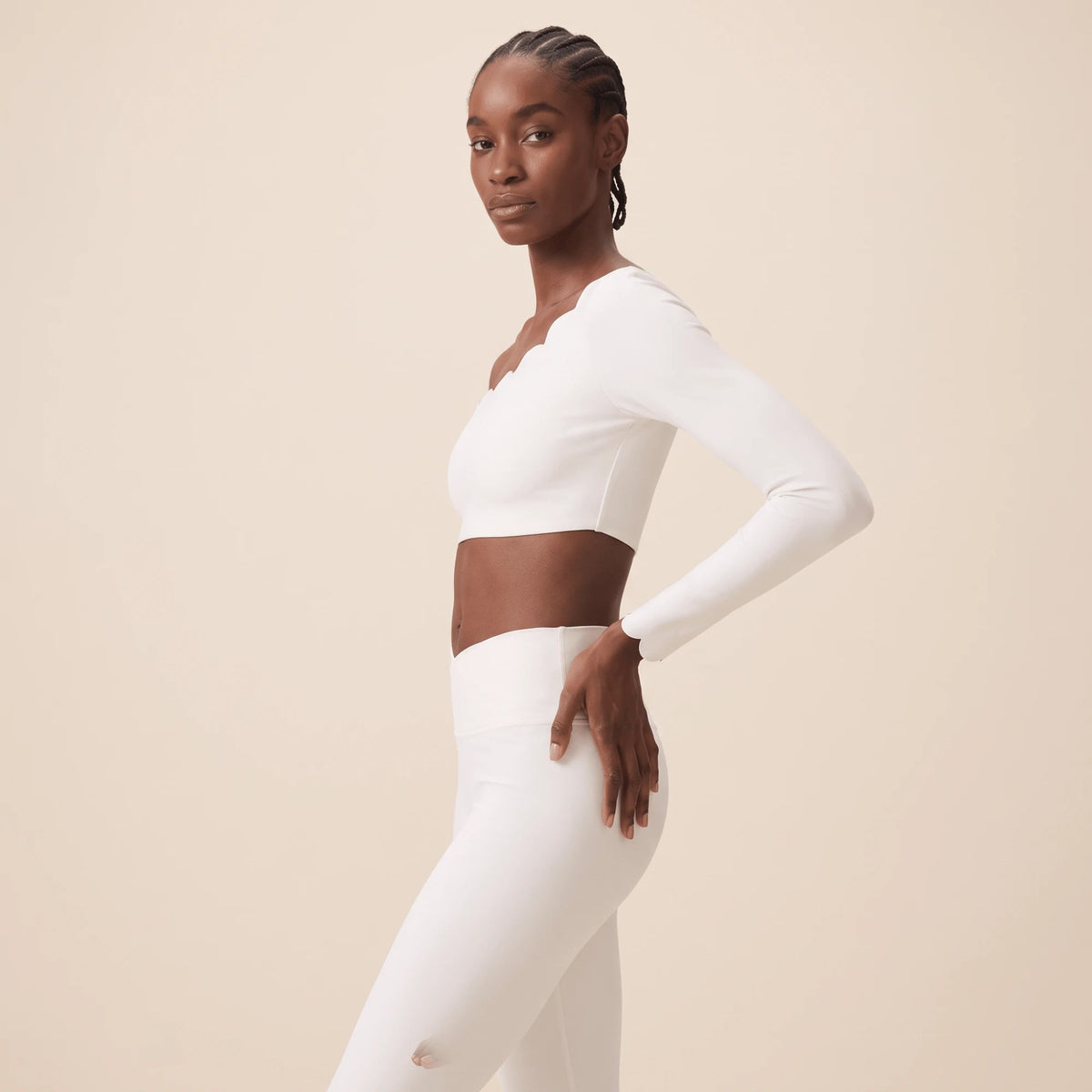 Legging blanc femme vu de profil, main sur la hanche : taille haute bien ajustée et coupe moulante qui épouse la hanche