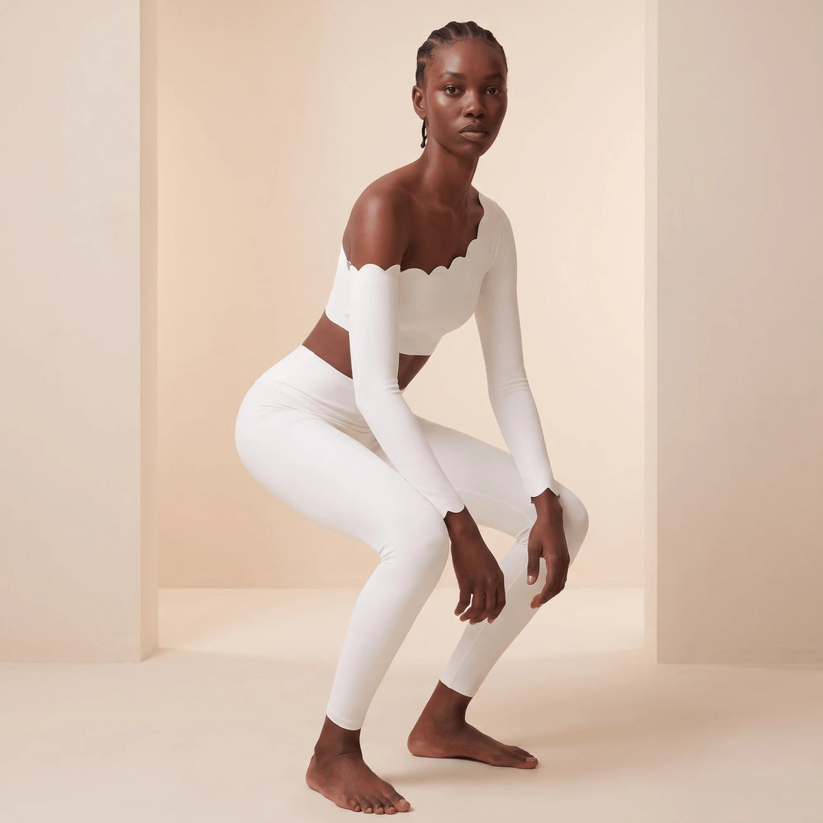 Legging de sport blanc en squat de trois quarts face : maille très élastique qui accompagne le mouvement pour la gym