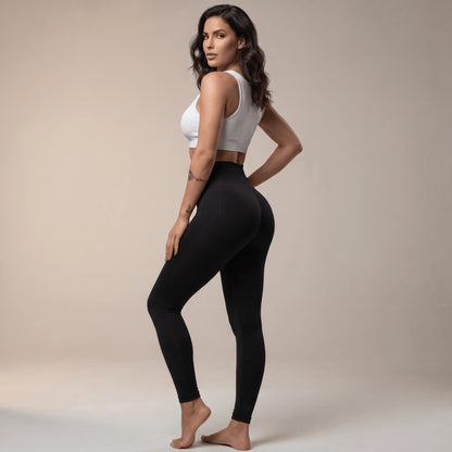 Legging de compression femme noir taille haute vu de dos, silhouette debout, studio beige
