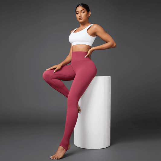 Legging de sport push up rose avec fines lignes verticales, pose assise élégante en studio minimaliste