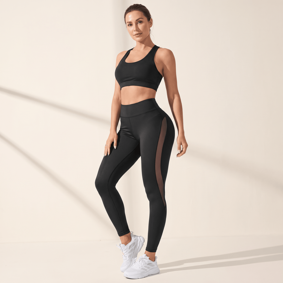 Legging noir femme taille haute, vue de trois quarts, panneau mesh sur le côté de la jambe