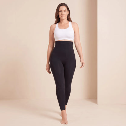 Legging noir taille très haute à large ceinture, porté avec une brassière blanche à dos nageur, mannequin de face en marche