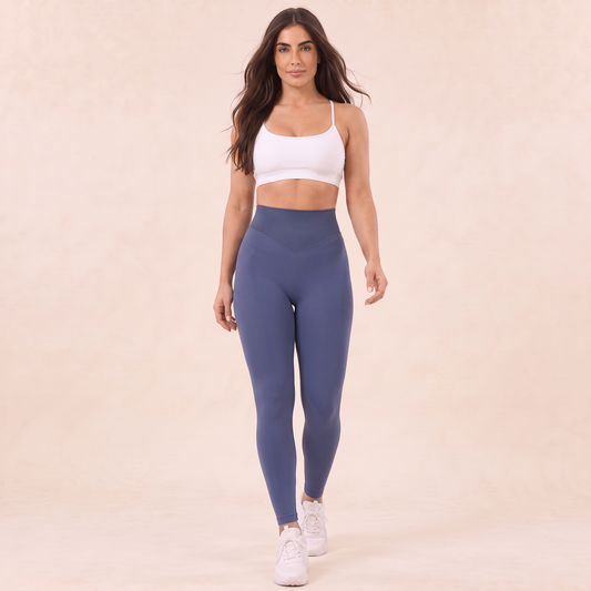 Legging gainant gris bleu taille haute porté en marchant, vue de face avec brassière blanche cheveux laché