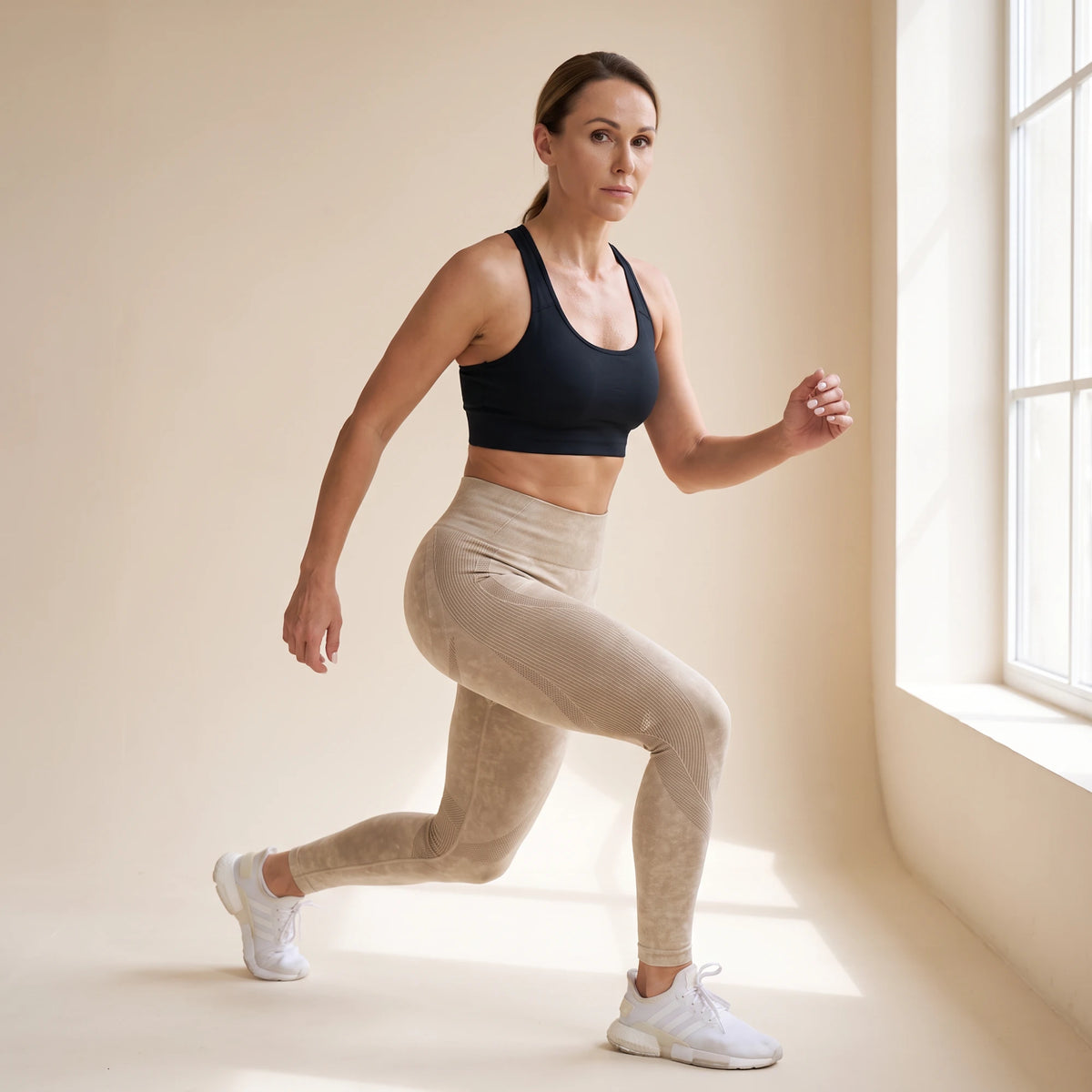 Legging galbant sans couture beige en fente avant pendant une séance de sport, studio crème