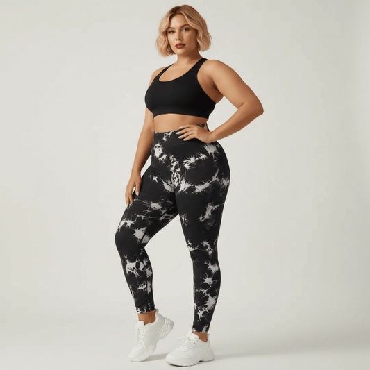 Legging grande taille femme taille haute seamless imprimé tie-dye noir et blanc pose trois quarts face main sur la hanche studio crème