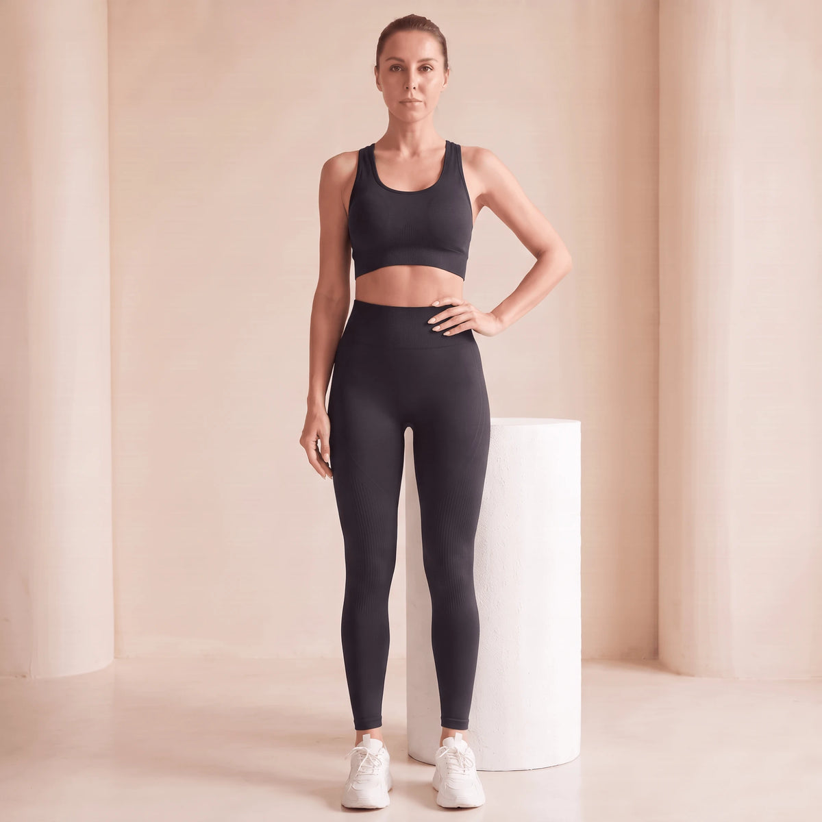 Legging noir taille haute sans couture, effet ventre plat, vu de face, main sur la hanche