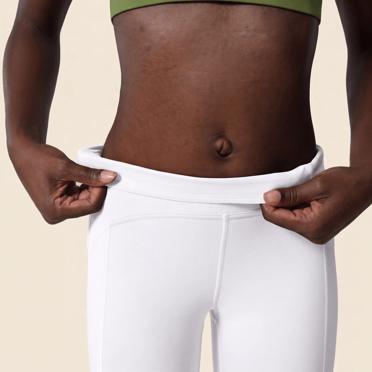 Ceinture du legging blanc que la main abaisse : intérieur doublé et bande côtelée de la taille haute