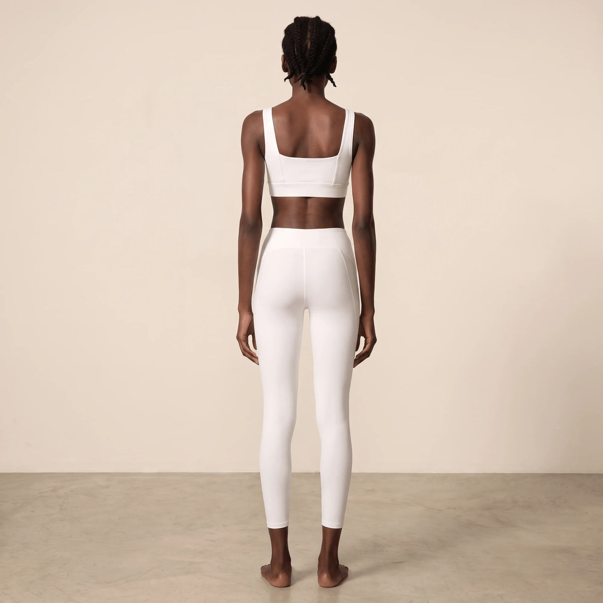 Legging blanc sport vu de dos en pied : silhouette nette, taille haute et longueur cheville avec brassière blanche