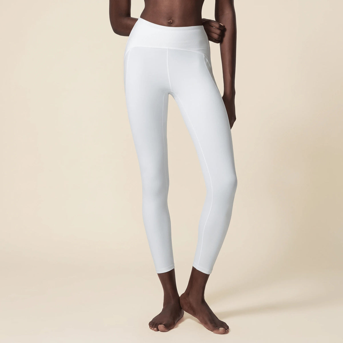 Gros plan sur la ceinture côtelée du legging blanc taille haute, de face, avec coutures plates et panneaux latéraux