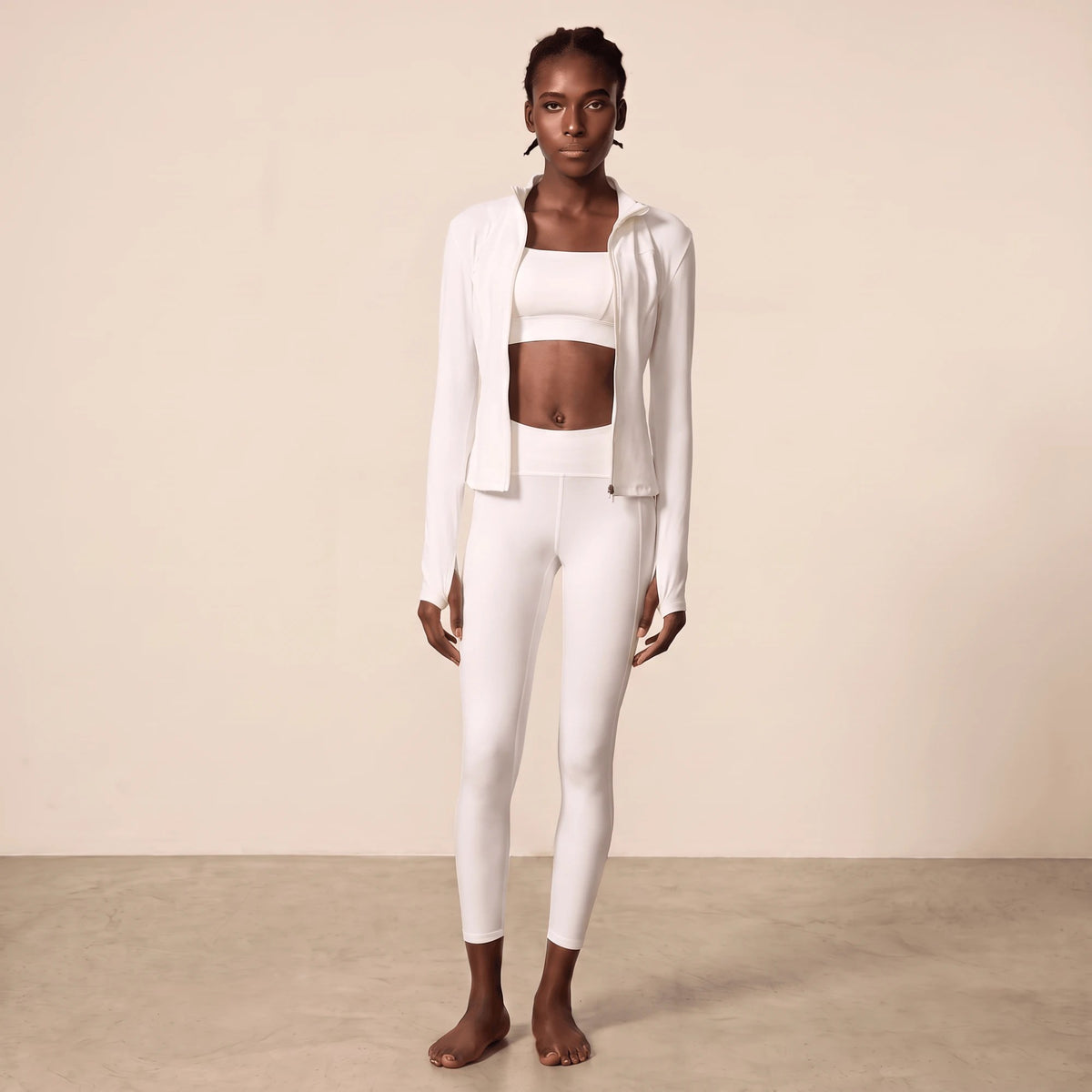 Legging sport blanc taille haute porté en tenue blanche complète avec veste zippée ouverte, brassière carrée, ceinture côtelée et longueur cheville