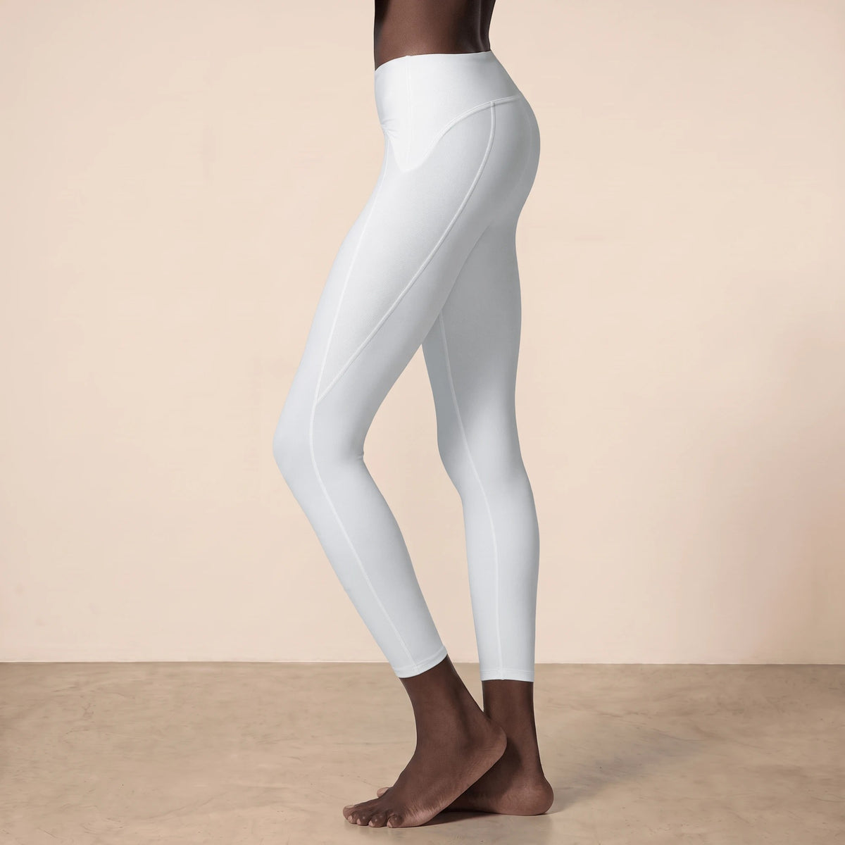 Profil du legging blanc sport 7/8 : panneau côtelé sur la hanche, coutures plates et taille haute bien ajustée
