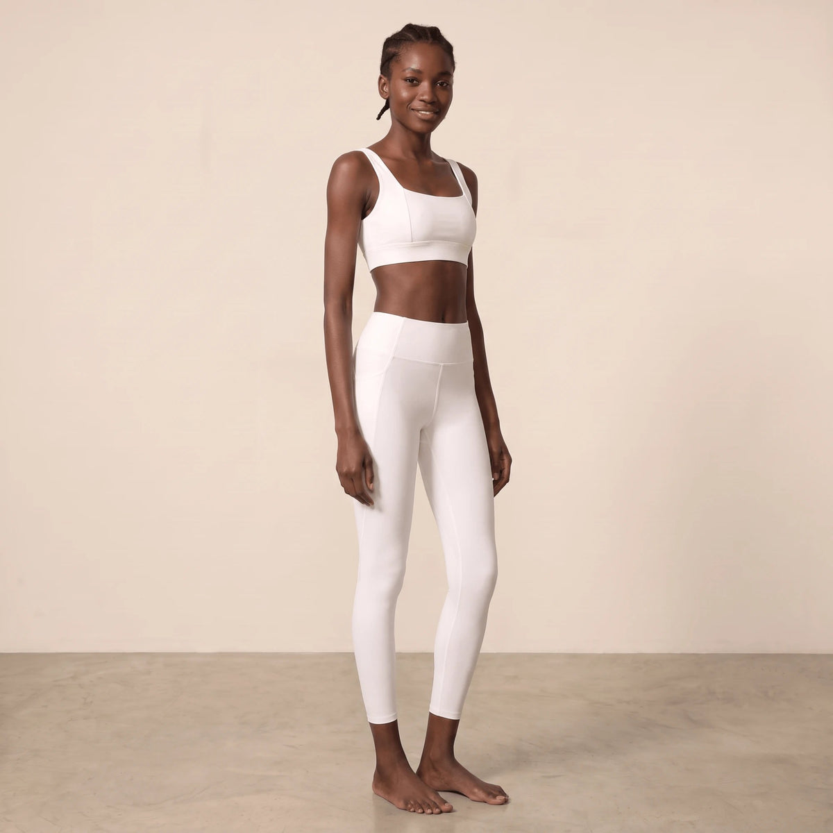 Legging blanc femme taille haute porté en trois-quarts par un mannequin souriante, ceinture côtelée et coupe ajustée