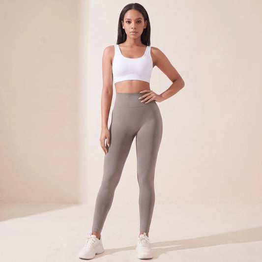 Legging femme taille haute gainant taupe, vu de face, main sur la hanche, large ceinture côtelée