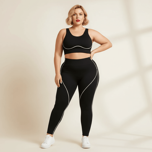 Pantalon de yoga femme grande taille noir liserés blancs taille haute vue de face main sur la hanche fond studio crème