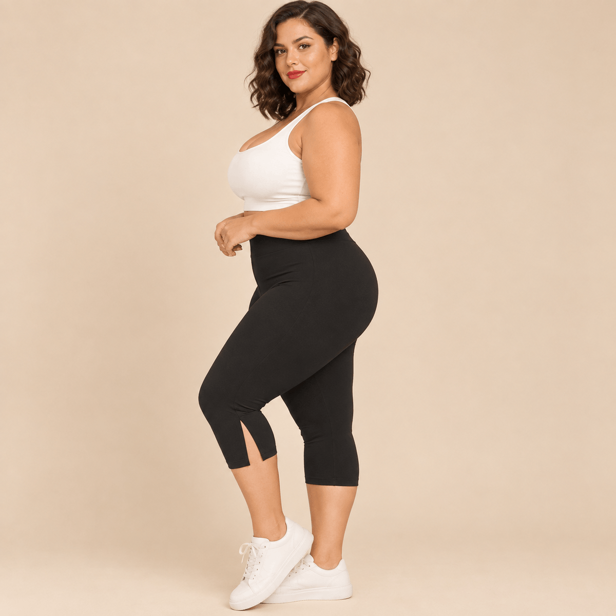 Short long sport femme grande taille noir capri compression taille haute gainant, vue de profil montrant la longueur genou , fond studio crème
