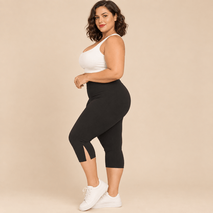 Short long sport femme grande taille noir capri compression taille haute gainant, vue de profil montrant la longueur genou , fond studio crème