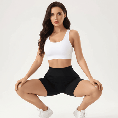 Short noir femme sport taille haute avec poches latérales en squat vue de face