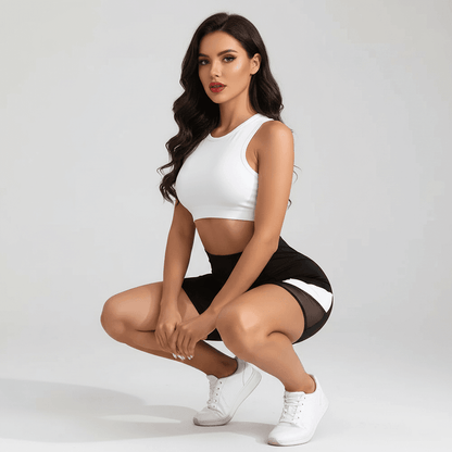 Short sport avec poche femme : leggings noir et short court blanc, femme en train de s’asseoir en squat, chaussures blanches.