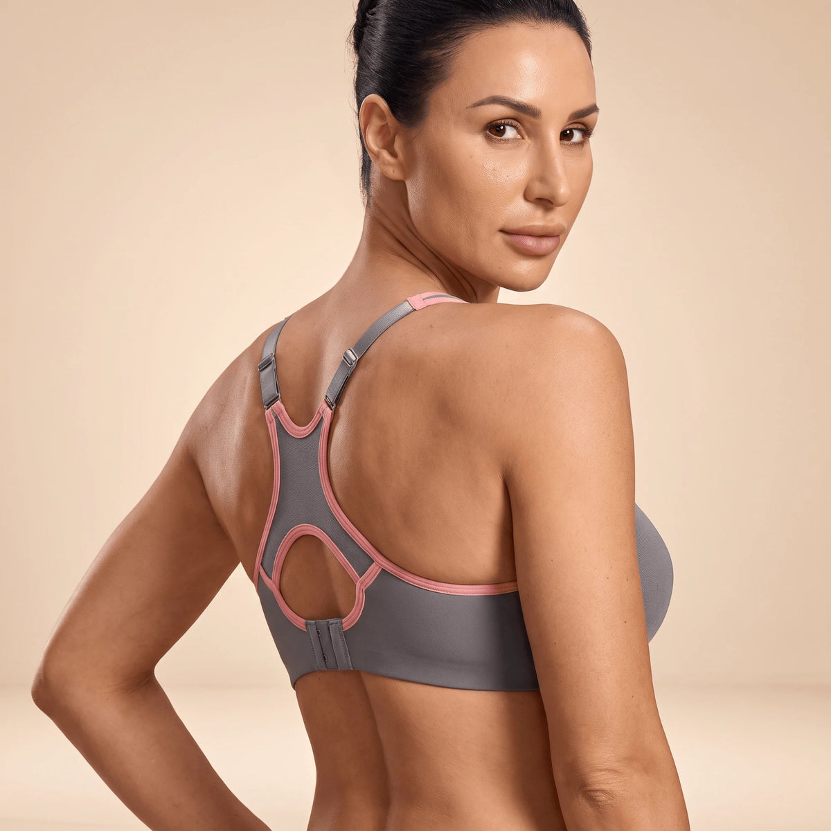 Dos du soutien-gorge de sport gris, ouverture ronde, bretelles réglables et fermeture à agrafes