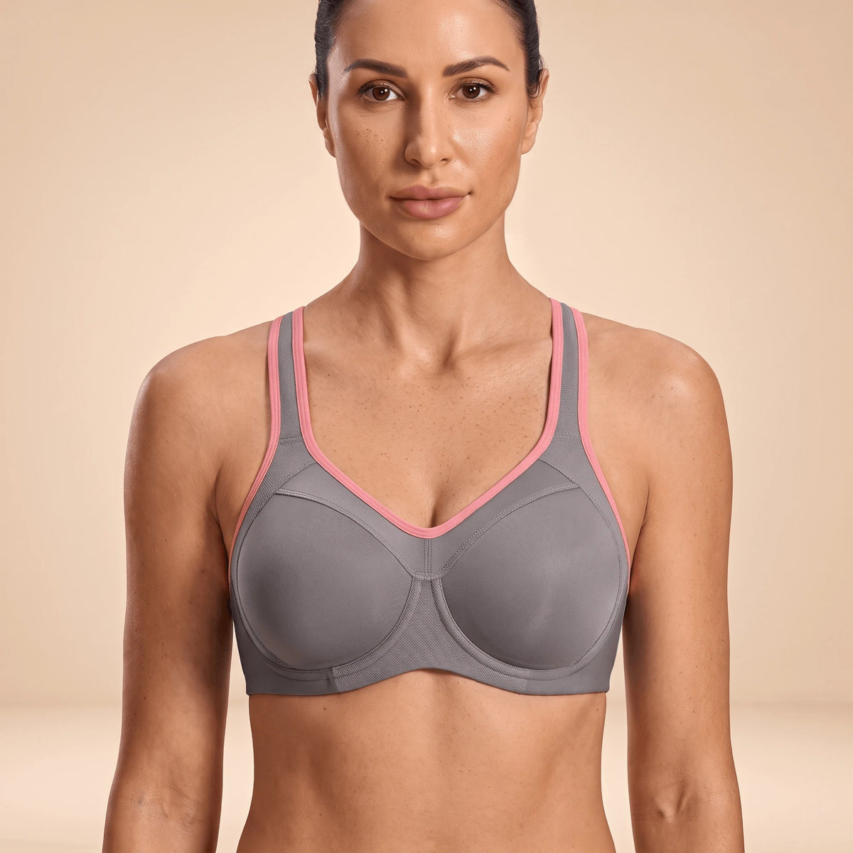 Soutien-gorge de sport gris à armatures et liseré rose, porté de face