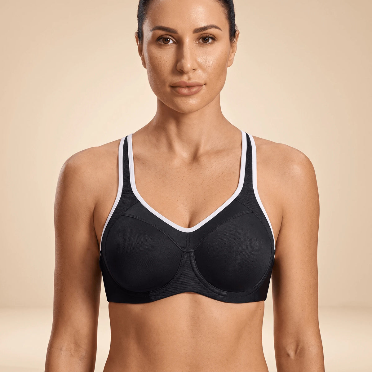 Soutien-gorge de sport noir à armatures et liseré blanc, porté de face, dos nageur