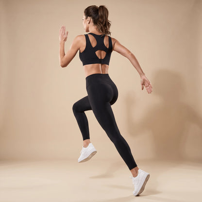 Soutien-gorge sportif noir vu de dos pendant la course, ouverture ronde et agrafes