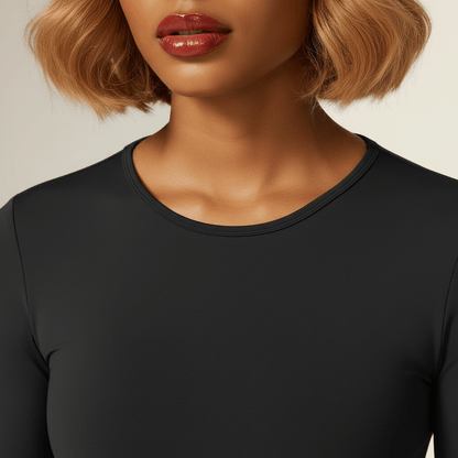 T-shirt compression femme manches longues noir – zoom détail col rond, finitions et coutures premium, fond studio ivoire