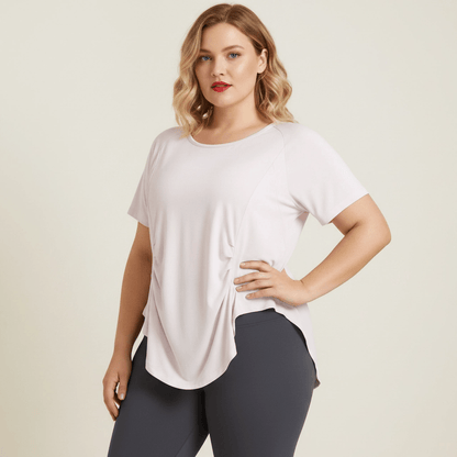 T-shirt de sport femme grande taille rose pâle yoga dos ouvert fronces latérales vue face trois-quarts fond studio crème