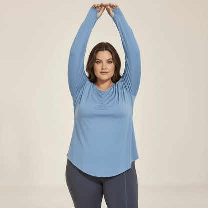 Femme portant un haut manches longues grande taille bleu gris, vue de face en léger mouvement, liberté d'épaule et manches raglan, studio fond ivoire.