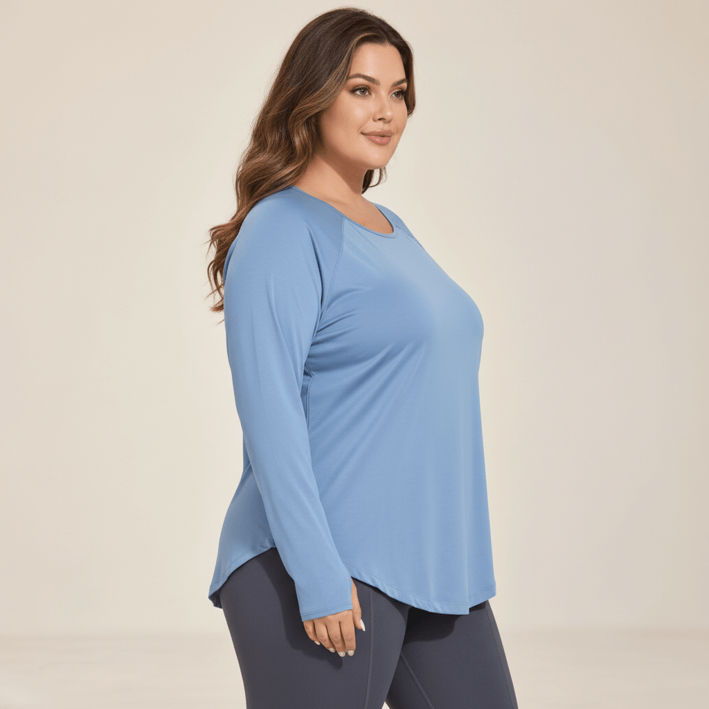 Tee shirt manches longues grande taille bleu gris vu de profil, ourlet arrondi qui couvre les hanches, studio fond ivoire.