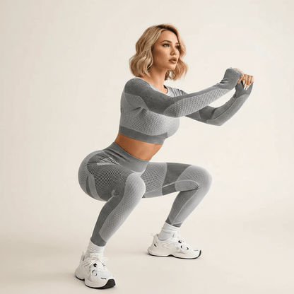 Tenue crossfit femme grise en pose de squat, ensemble seamless training dynamique, maille texturée tummy control, studio ivoire