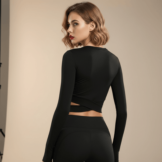 Top manches longues croisé femme noir – vue de dos, détail croisé bas du dos, legging assorti, femme blonde carré wavy fond studio ivoire