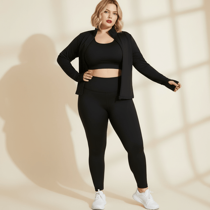 Veste de sport grande taille noire portée ouverte sur une brassière, allure fashion sport, fond studio crème