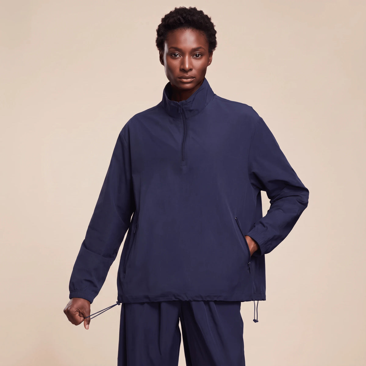 Veste running femme imperméable bleu marine portée de face, col montant et demi-zip