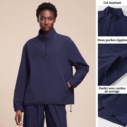 Veste running femme imperméable bleu marine : col montant, deux poches zippées et ourlet à cordon