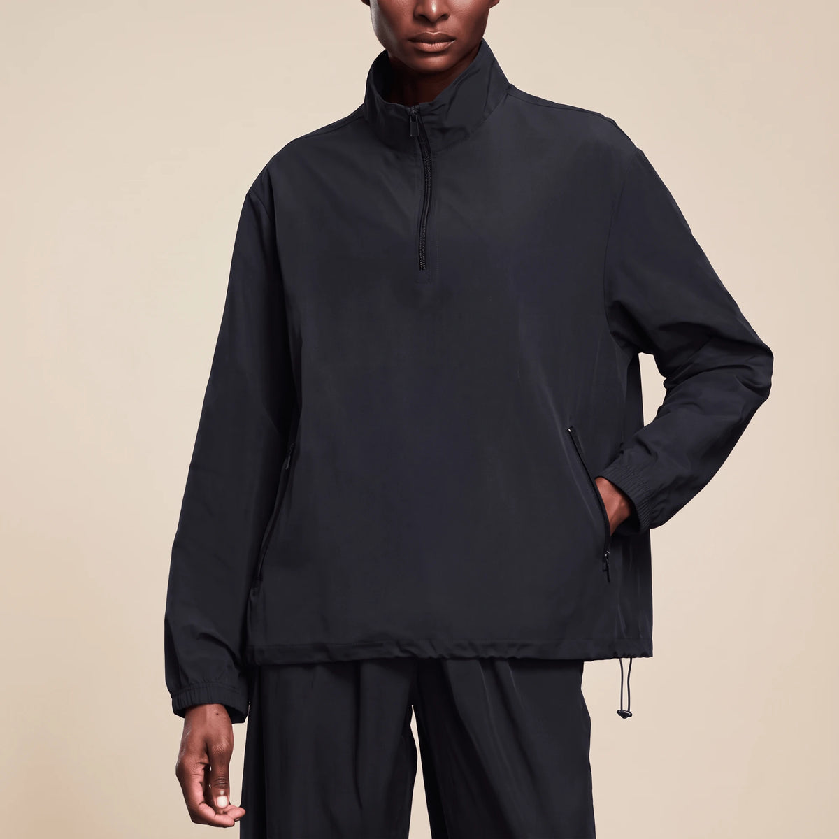 Veste running femme imperméable noire portée de face, fermeture éclair au quart