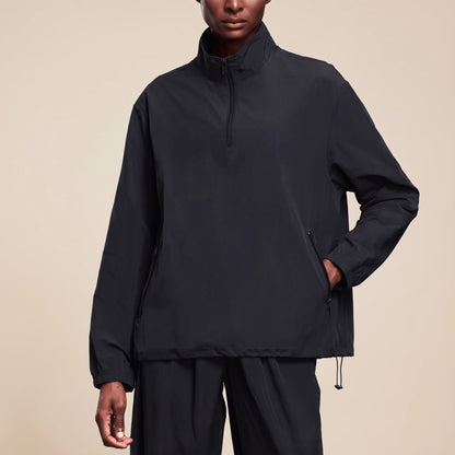 Veste running femme imperméable noire portée de face, fermeture éclair au quart