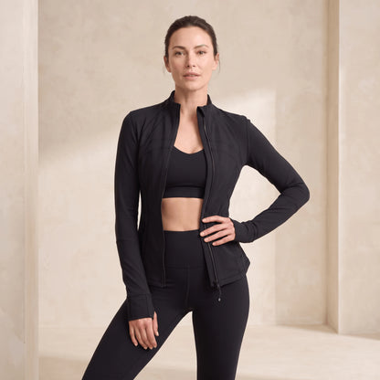 Veste sport femme doublée polaire noire ouverte sur une brassière, zip intégral