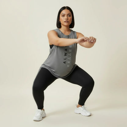Tenue de sport grande taille femme en mouvement pendant un squat, le débardeur reste en place