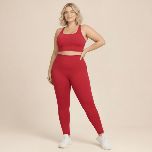 Vetement fitness femme grande taille raspberry red, ensemble brassiere et legging taille haute, nouvelle pose, fond studio beige.